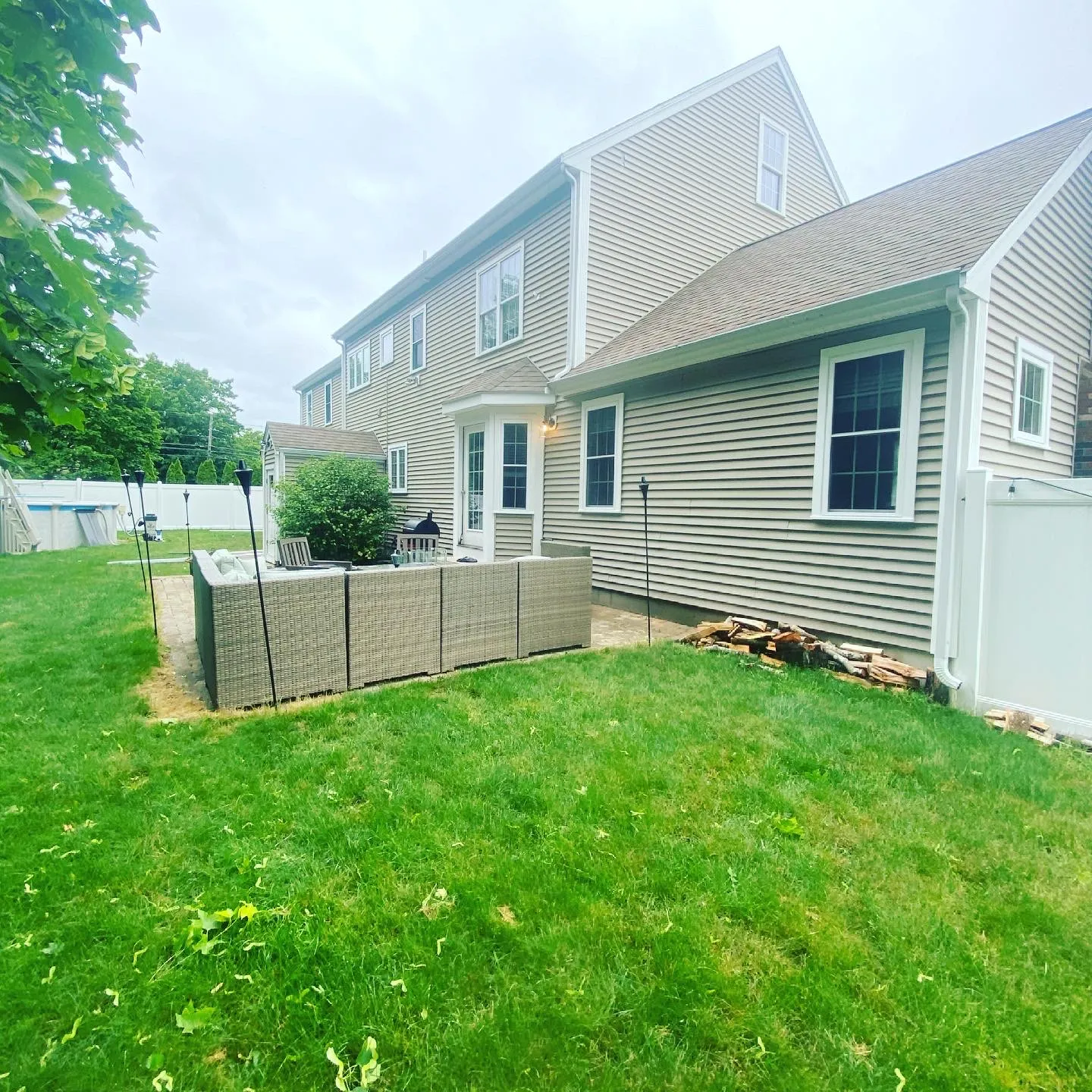 Freshly cleaned home exterior and gutter system in a backyard setting